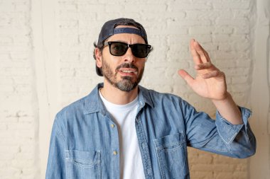 genç çekici hippi, trendy tarzı rahat şapka gayrı giyinme tutum ile mutlu poz serin gülümseyen adam arıyorum. Erkek moda kavramı.