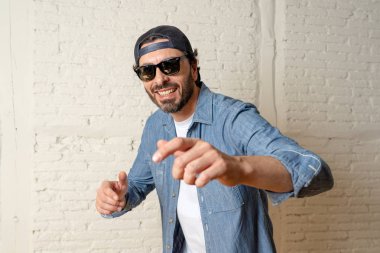 genç çekici hippi, trendy tarzı rahat şapka gayrı giyinme tutum ile mutlu poz serin gülümseyen adam arıyorum. Erkek moda kavramı.