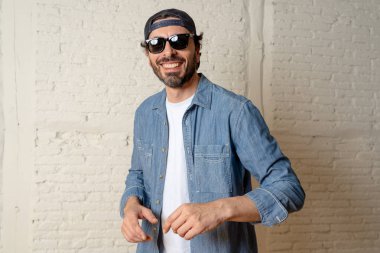 genç çekici hippi, trendy tarzı rahat şapka gayrı giyinme tutum ile mutlu poz serin gülümseyen adam arıyorum. Erkek moda kavramı.