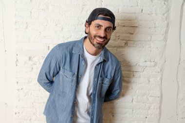 genç çekici hippi, trendy tarzı rahat şapka gayrı giyinme tutum ile mutlu poz serin gülümseyen adam arıyorum. Erkek moda kavramı.