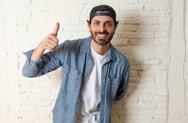 genç çekici hippi, trendy tarzı rahat şapka gayrı giyinme tutum ile mutlu poz serin gülümseyen adam arıyorum. Erkek moda kavramı. Başparmak göstermek yukarıya adam