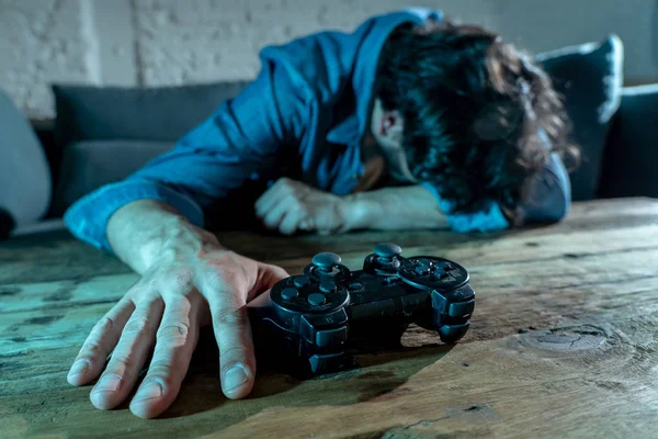 Bağımlılık ve bağımlılık kavramı. iskambil video spor erkek konsol oyun kavramı için bağımlısı pad joystick ile genç adam yakın çekim.