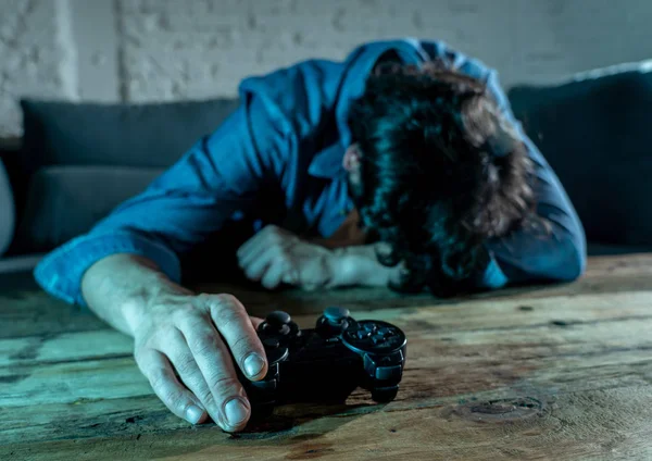 Bağımlılık ve bağımlılık kavramı. iskambil video spor erkek konsol oyun kavramı için bağımlısı pad joystick ile genç adam yakın çekim.