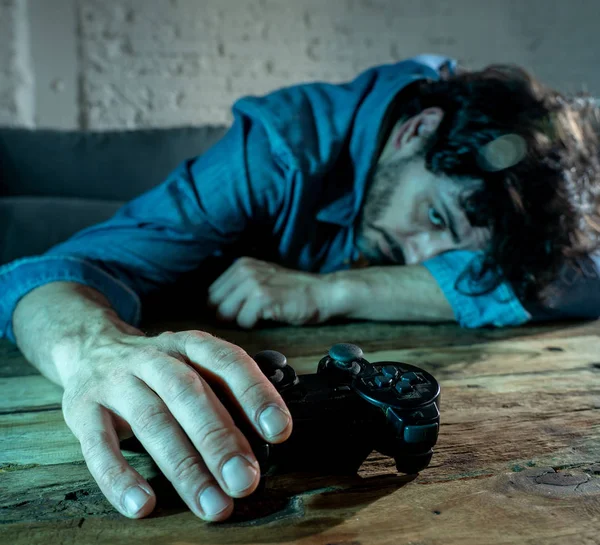 Bağımlılık ve bağımlılık kavramı. iskambil video spor erkek konsol oyun kavramı için bağımlısı pad joystick ile genç adam yakın çekim.