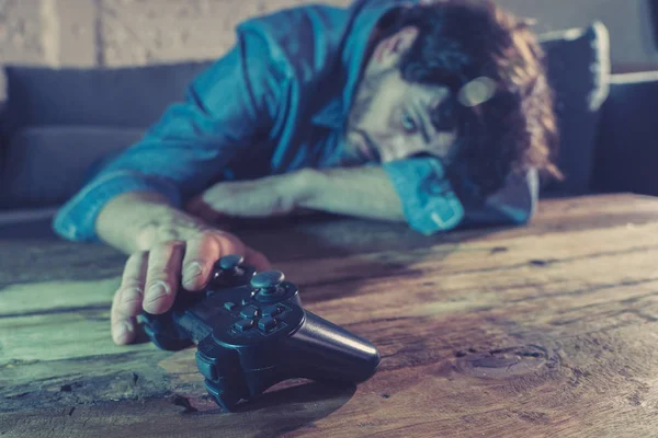 Bağımlılık ve bağımlılık kavramı. iskambil video spor erkek konsol oyun kavramı için bağımlısı pad joystick ile genç adam yakın çekim.