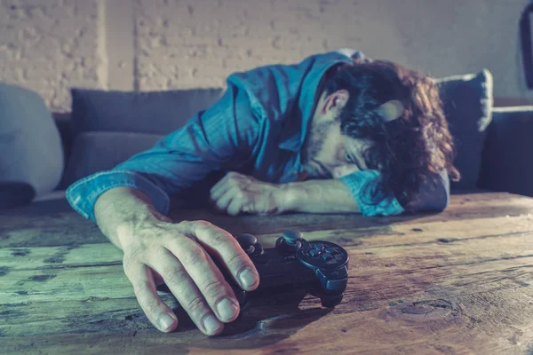 Bağımlılık ve bağımlılık kavramı. iskambil video spor erkek konsol oyun kavramı için bağımlısı pad joystick ile genç adam yakın çekim.