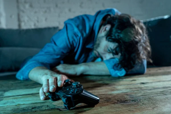 Bağımlılık ve bağımlılık kavramı. iskambil video spor erkek konsol oyun kavramı için bağımlısı pad joystick ile genç adam yakın çekim.