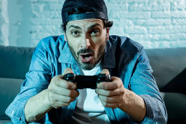 oturma odası kanepe ve video oyunları oyun bağımlılığı kavramında eğleniyor ucube yoğun yüz ifadesi ile uzaktan kumanda joystick kullanarak çalmayı genç heyecanlı latin adam evde oturan