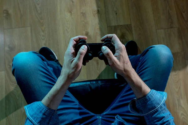 Bağımlılık ve bağımlılık kavramı. Genç adamın elleri üzerinde video oyunları oynarken pad joystick ile kapatın. Konsol oyun kavramı için bağımlısı erkek.