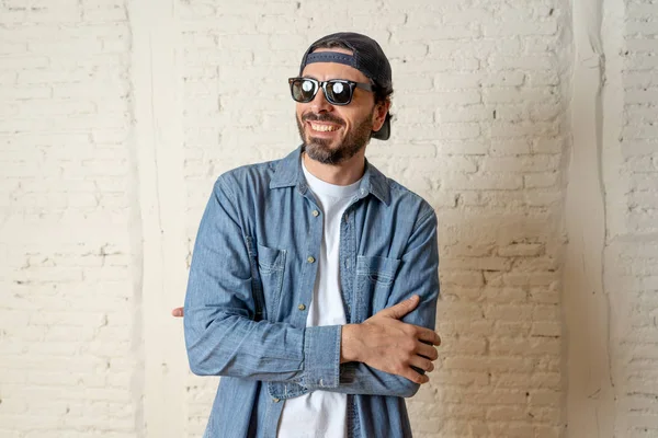 genç çekici hippi, trendy tarzı rahat şapka gayrı giyinme tutum ile mutlu poz serin gülümseyen adam arıyorum. Erkek moda kavramı.