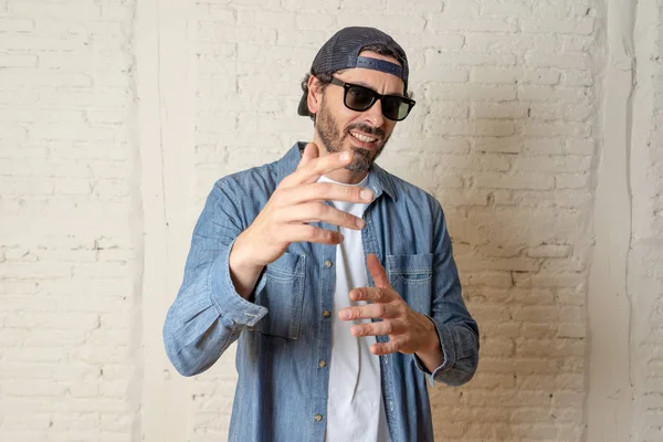 genç çekici hippi, trendy tarzı rahat şapka gayrı giyinme tutum ile mutlu poz serin gülümseyen adam arıyorum. Erkek moda kavramı.