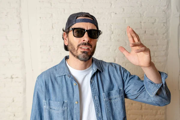 genç çekici hippi, trendy tarzı rahat şapka gayrı giyinme tutum ile mutlu poz serin gülümseyen adam arıyorum. Erkek moda kavramı.