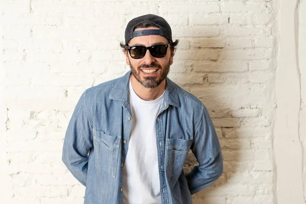 genç çekici hippi, trendy tarzı rahat şapka gayrı giyinme tutum ile mutlu poz serin gülümseyen adam arıyorum. Erkek moda kavramı.