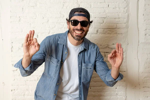 genç çekici hippi, trendy tarzı rahat şapka gayrı giyinme tutum ile mutlu poz serin gülümseyen adam arıyorum. Erkek moda kavramı. Tamam gösterilen adam 