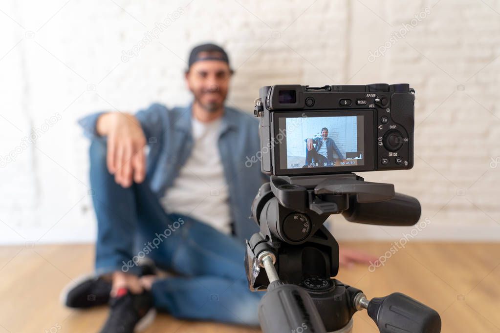 close up of  young happy male blogger on camera screen filming a video for the internet in technology concept