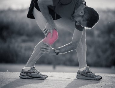Portre siyah ve beyaz spor adam koşucu dizi kırmızı renkte bir çalışma yaralanma sonra ağır yaralı ağrı spor fitness yaralanma kavram yerini göster.