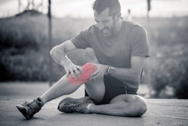 Portre siyah ve beyaz spor adam koşucu dizi kırmızı renkte bir çalışma yaralanma sonra ağır yaralı ağrı spor fitness yaralanma kavram yerini göster.