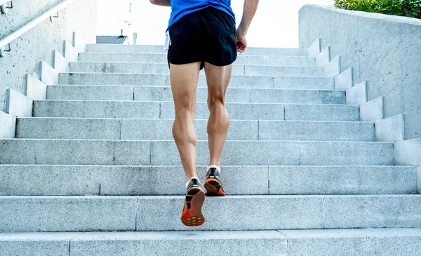 Man runner running on stairs in urban city sport training young male jogger athlete training and doing workout outdoors in city. Fitness and exercising outdoors urban environment concept.