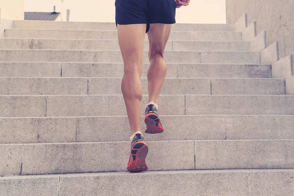 Man runner running on stairs in urban city sport training young male jogger athlete training and doing workout outdoors in city. Fitness and exercising outdoors urban environment concept.