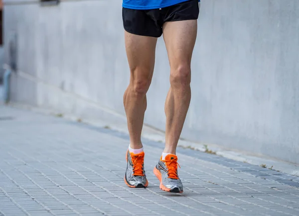 Closeup of sports mans legs running with sport background urban city backdrop in runner fitness concept with copy space