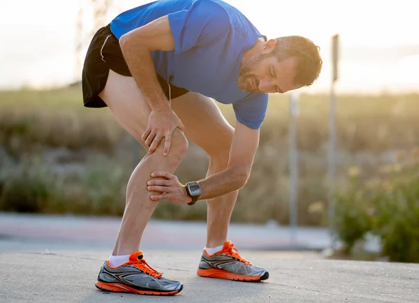 Joven Deportista Con Fuertes Piernas Atléticas Sosteniendo Rodilla Con Las — Foto de Stock