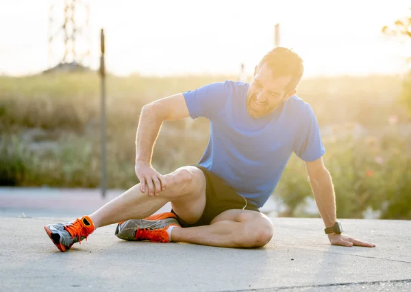 Joven Deportista Con Fuertes Piernas Atléticas Sosteniendo Rodilla Con Las — Foto de Stock