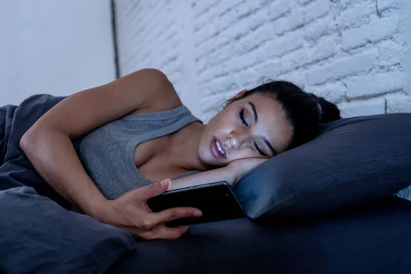 携帯電話のインターネット通信でスマートな携帯電話中に睡眠に落ちる疲れを使用して深夜にベッドで若い美人ラテン酷使概念とスマート フォン中毒 — ストック写真