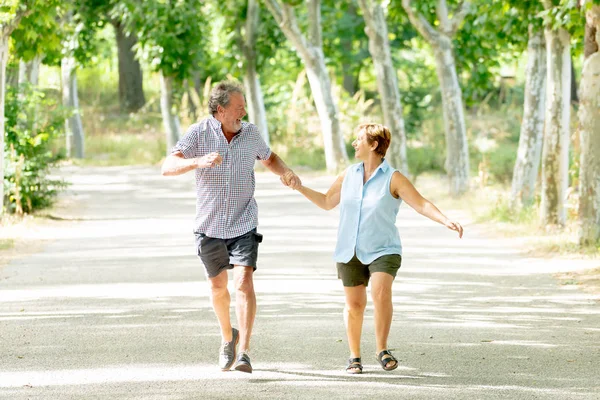 快乐的资深夫妇在爱奔跑和牵手在公园里 — 图库照片