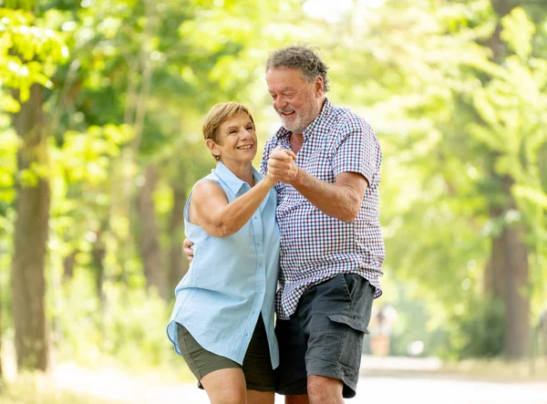 Mutlu üst düzey iki aşk içinde gülümseyen, dans ve parkta having fun.