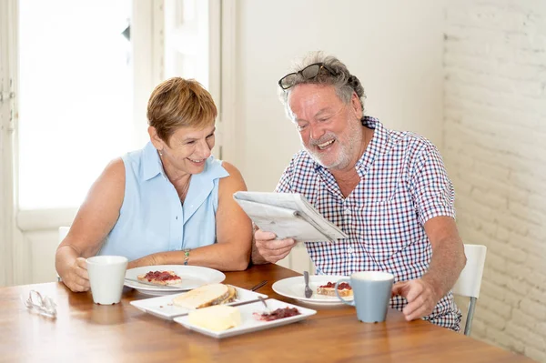 Attractive mature retired couple having breakfast together at home