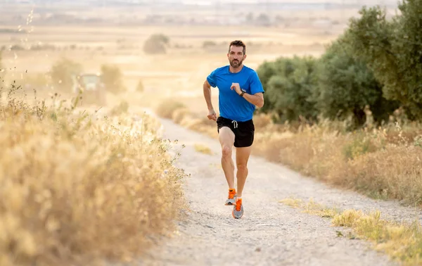 male fitness runner training on rural track