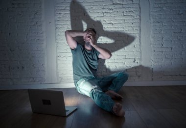Stalker ya da umutsuz ve siber zorbalık kavramı içinde aşağılanmış hissediyor dedikodu tarafından cyberbullying ve çevrimiçi varlık taciz acı bilgisayar dizüstü bilgisayar ile ciddi bir şekilde perişan genç erkekler istismar.