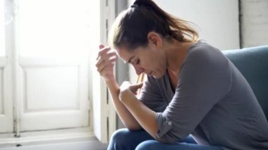 Genç çekici latin kadın evde oturma odası kanepe üzgün yalan yorgun ve ruh sağlığı, sorunları ve kırık kalp kavramı depresyon acı endişeli.