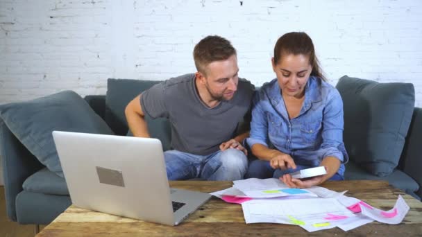 Νεαρό ζευγάρι ευτυχισμένο, πληρώνουν τους λογαριασμούς με το laptop — Αρχείο Βίντεο