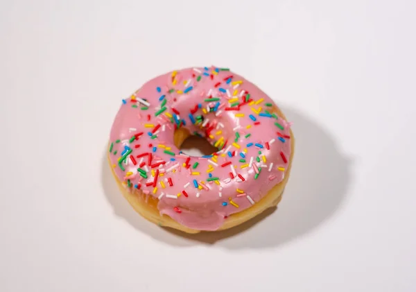 Donut with colorful sprinkles on white