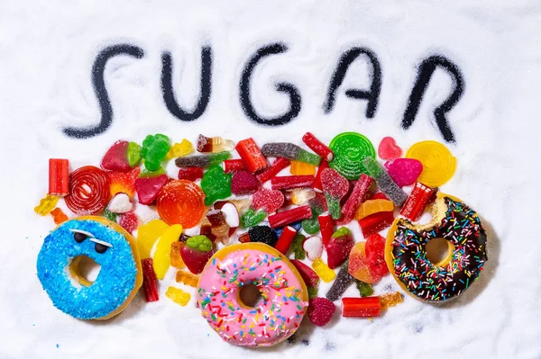 Mix of candies donuts and sugar in writing