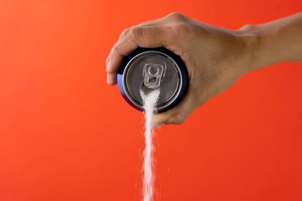 Hand holding a soda can pouring sugar — Stock Photo, Image