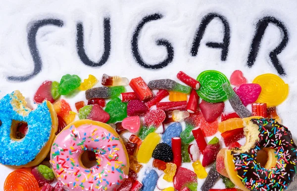 Mix of candies donuts and sugar in writing