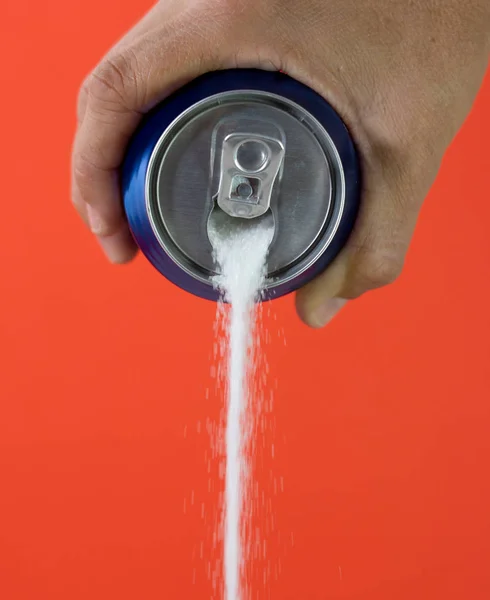 Hand holding a soda can pouring sugar — Stock Photo, Image