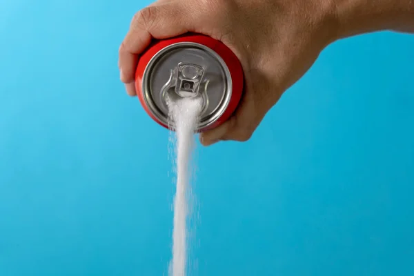 Hand holding a soda can pouring sugar — Stock Photo, Image