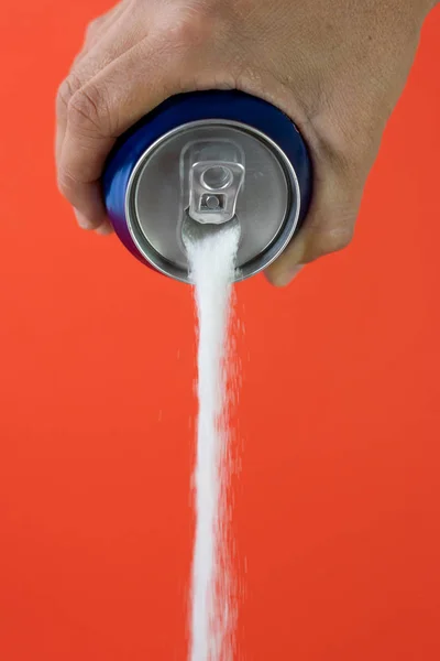 Hand holding a soda can pouring sugar — Stock Photo, Image