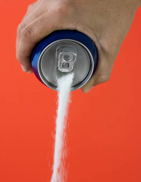 Hand holding a soda can pouring sugar — Stock Photo, Image