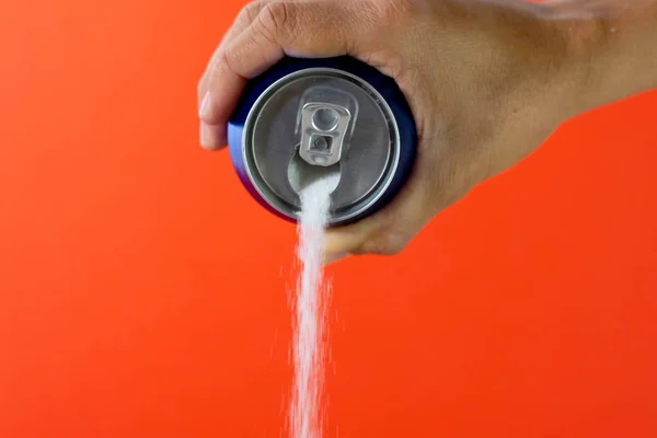 Hand holding a soda can pouring sugar — Stock Photo, Image