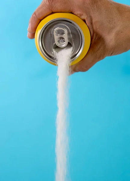 Hand holding a soda can pouring sugar