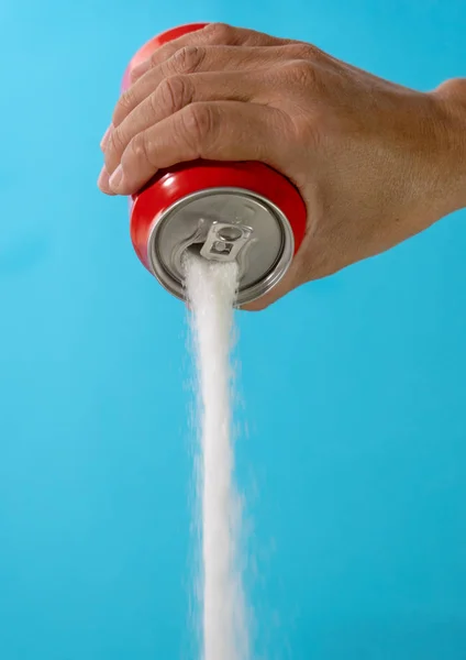 Hand holding a soda can pouring sugar