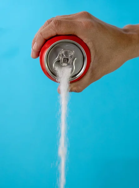 Hand holding a soda can pouring sugar