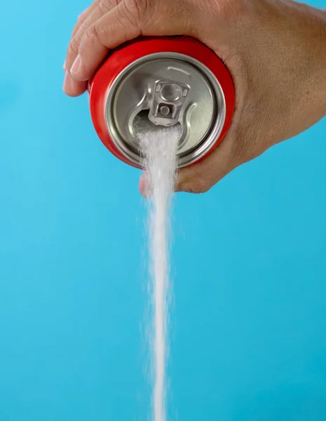 Hand holding a soda can pouring sugar