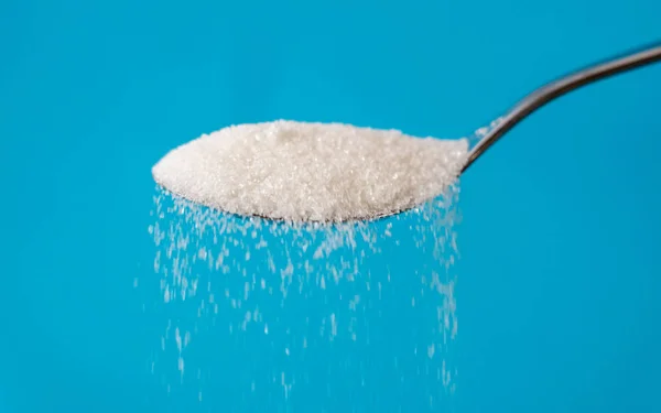 Socker hälla från en sked — Stockfoto
