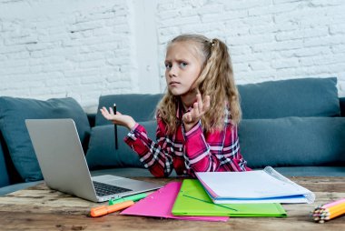 Sevimli İlköğretim öğrenci ile onu laptop evde zor atama yaparken duygu üzgün ve kafa karıştırıcı. Ödev ve çocuk eğitim kavramı.