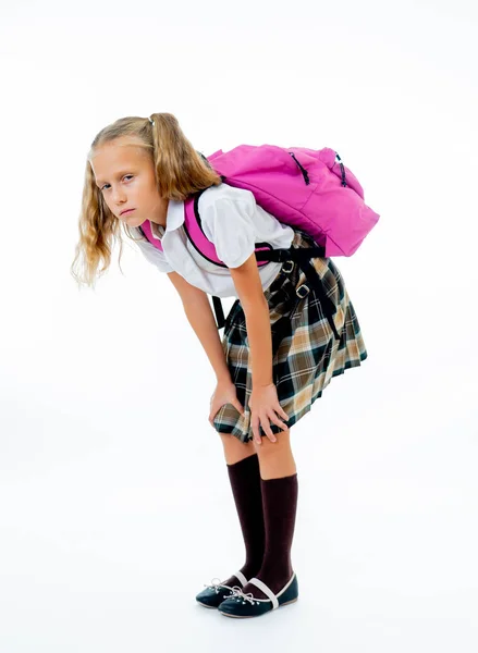 若いが疲れている 悲しいかわいい学校の女の子が彼女の背中に大きな重いスクール バッグと立っている白い背景の分離 — ストック写真